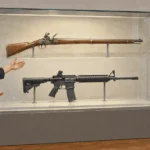 Conceptual painting of a museum curator comparing a historic musket and modern rifle behind glass.