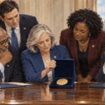 Lawmakers inspect a plain gold medal in a presentation case.