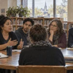 People discuss a local policy at a public library meeting.